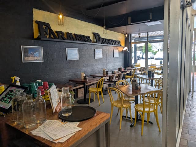 Interior with the bold Farmers Daughter sign and yellow bentwood chairs